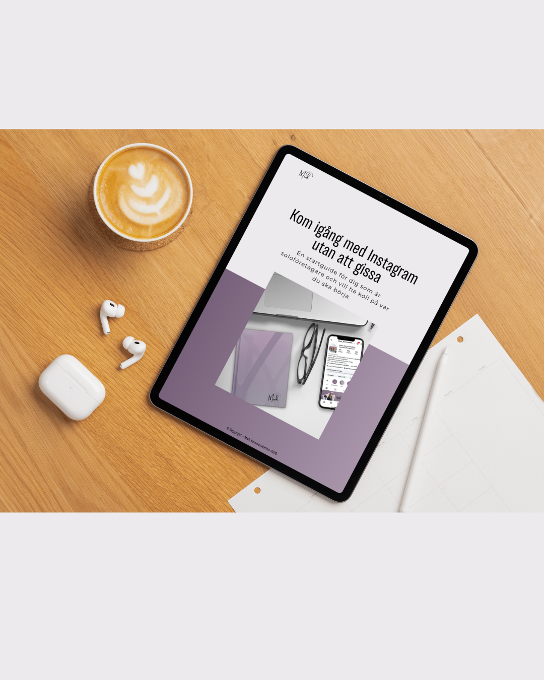 Ett bord med en ipad som visar en framsida på en pdf 